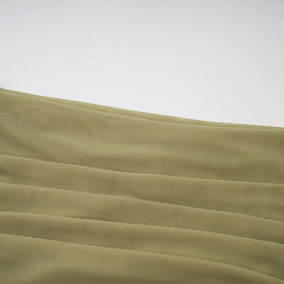 Close-up of a textured beige fabric with folds on a light gray background