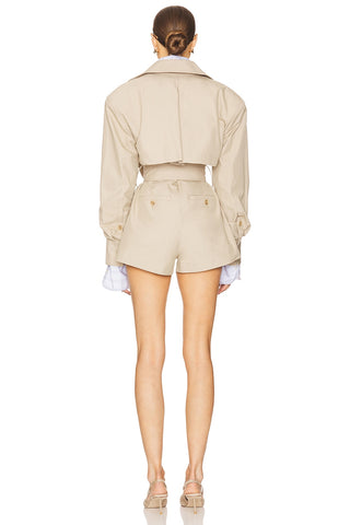 Person wearing a beige jacket and shorts set on a white background