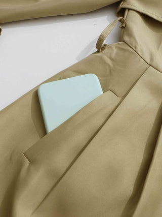 Beige coat with a light blue phone case in the pocket on a white background