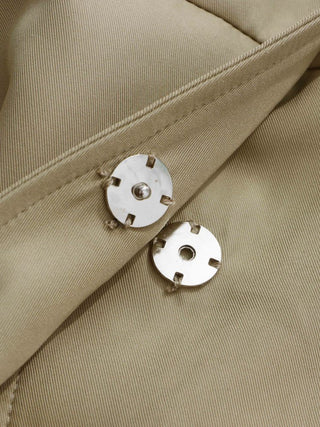 Close-up of beige fabric with metal buttons