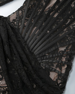 Close-up of black lace fabric with a fan-like design on a white background