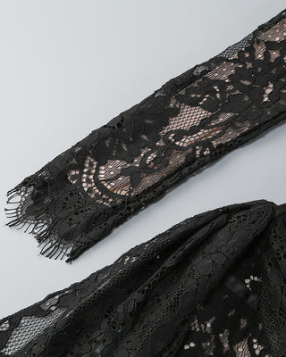 Black lace fabric with intricate patterns on a light gray background