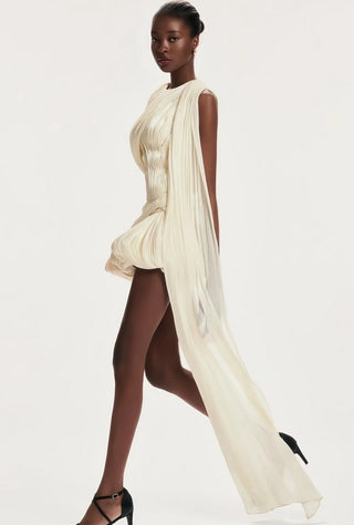 Woman wearing a flowing white dress on a plain background