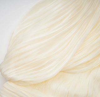 Close-up of draped cream-colored fabric on a light background
