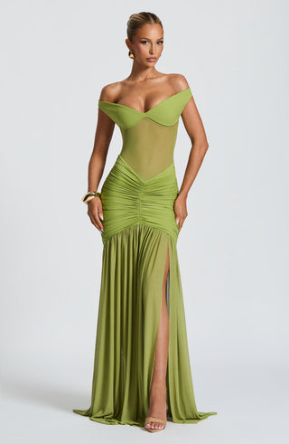 Woman wearing a green off-shoulder evening gown on a white background