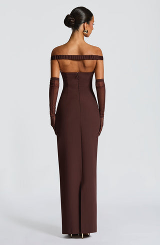 Woman wearing a brown off-shoulder evening gown with long gloves on a white background