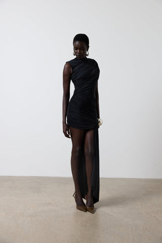 Woman wearing a black dress with sheer panels on a plain background