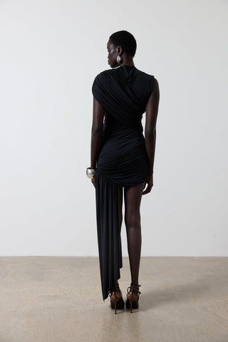 Woman wearing a black dress standing against a white background