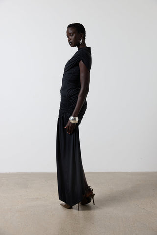 Woman wearing a black dress standing against a white background