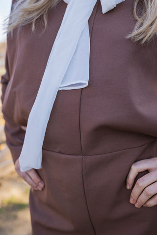 Brown mini dress with shoulder pads, designed for business wear. A chic fall/autumn designer dress featuring long sleeves and a tulle bow scarf, perfect for a professional and stylish look. Cielie Vienna