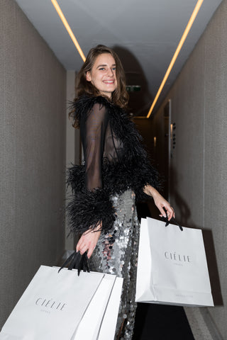Glamorous high-slit sequin skirt styled with heels and mesh blouse