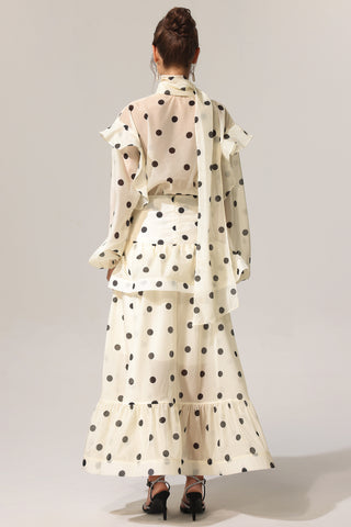 Woman wearing a polka dot outfit with a plain background