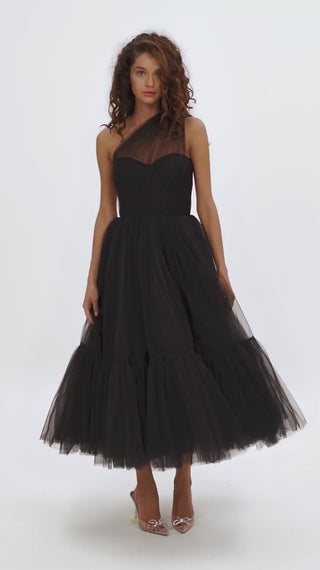 Elegant black cocktail dress with asymmetric neckline and flowing tulle skirt.