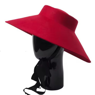 Red wide-brimmed hat on a black mannequin head against a white background