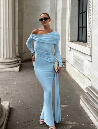 Woman in a light blue off-shoulder gown standing in front of classical architecture.