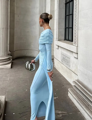 Woman in a light blue dress standing in front of classical architecture