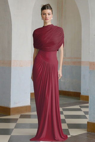 Woman wearing a burgundy evening gown in an arched hallway with checkered floor.