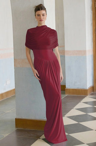 Woman wearing a burgundy evening gown in an indoor setting with a checkered floor.