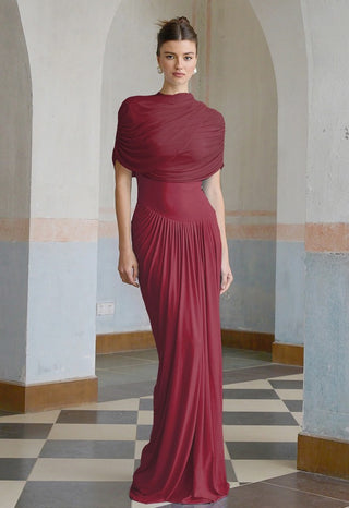 Woman wearing a burgundy evening gown in an elegant hallway.